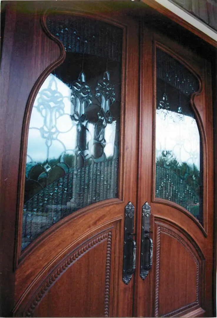Ornate wooden double doors with decorative glass panels and metal handles.
