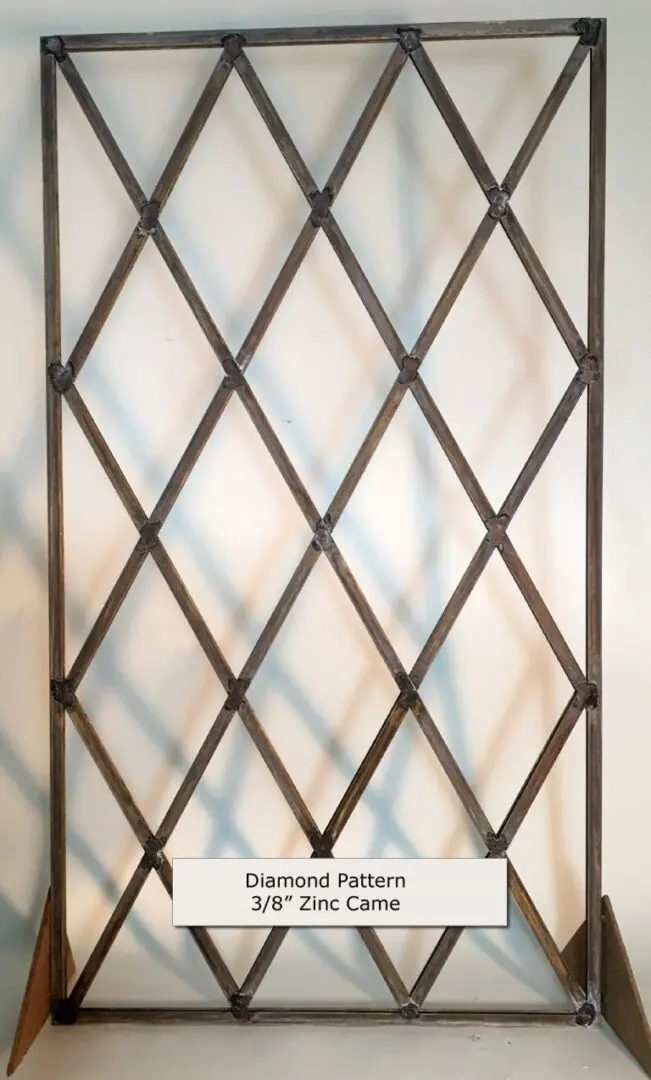 Metal grid with a diamond pattern made from 3/8" zinc came, displayed upright.
